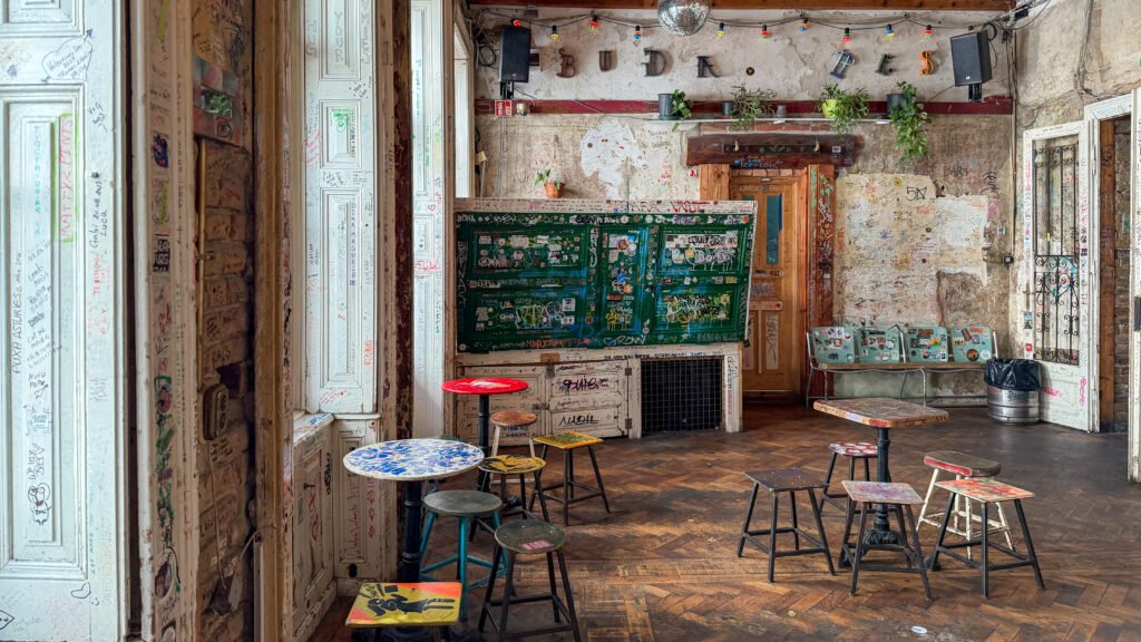 Inside ruin bar in Budapest with graffiti on walls.