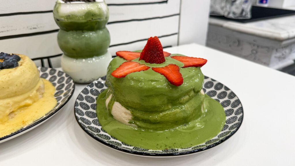 Green matcha-covered pancakes with strawberry slices.
