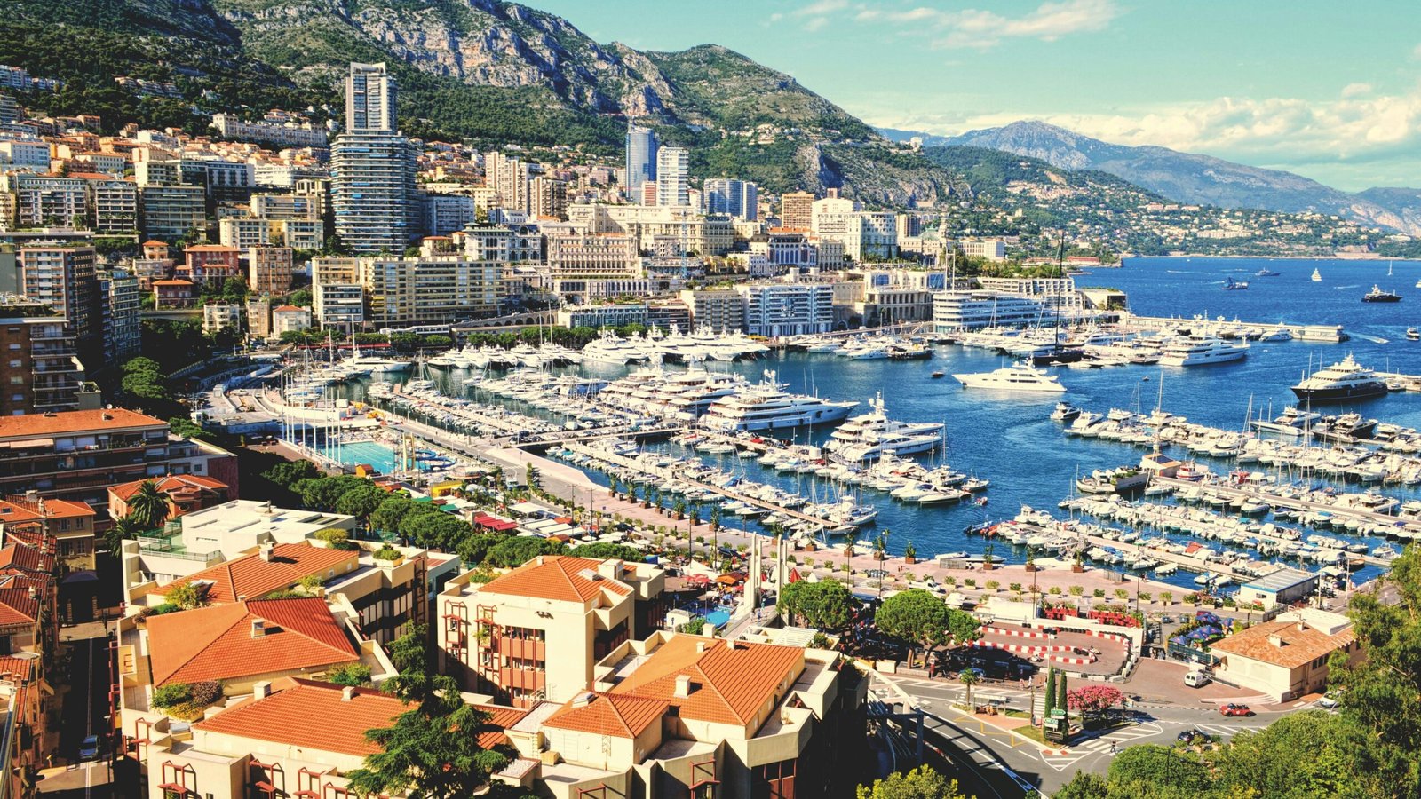 Monaco Casino | Krista the Explorer Coastal city harbour lined with yachts and modern buildings.
