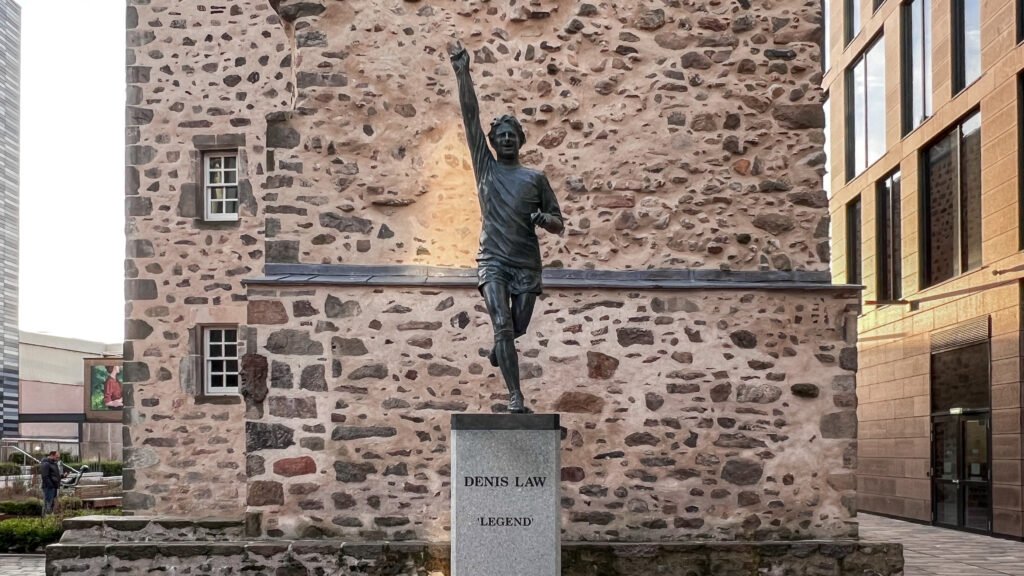 Denis Law Aberdeen | Krista the Explorer Bronze statue of football legend Denis Law with his right arm raised.