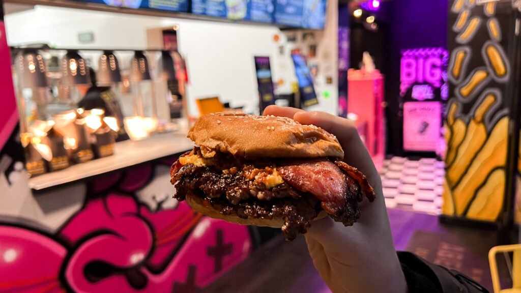ABERDAM Dutch Fries Aberdeen | Krista the Explorer Person holding a smash burger inside colourful street food restaurant.