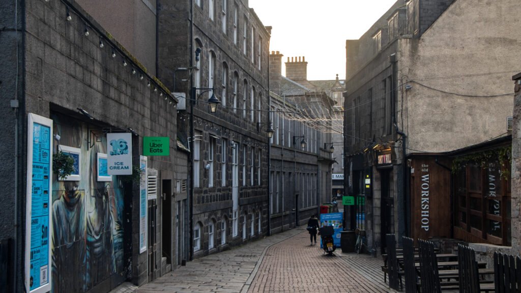 Shiprow Village Aberdeen | Krista the Explorer Narrow cobblestone street lined with dark stone buildings.