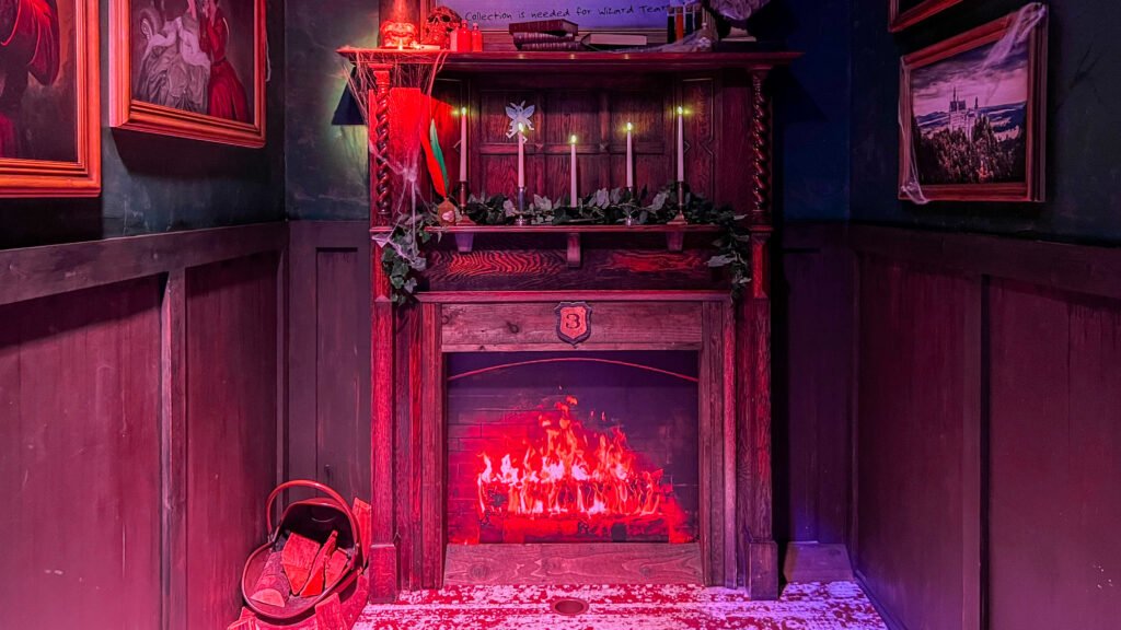 The Hole in Wand Blackpool | Krista the Explorer Ornate wooden fireplace mantel with five candles, ivy garland, and a warm red glow.