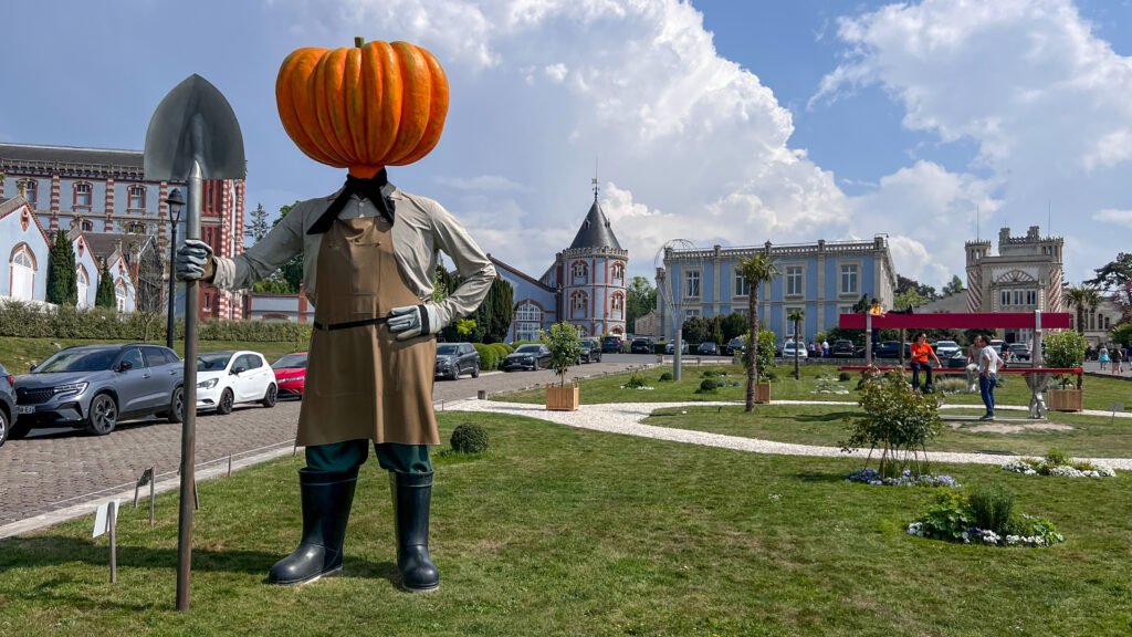 Domaine Vranken-Pommery Reims | Krista the Explorer Life-size scarecrow statue with a large pumpkin head holding a shovel.