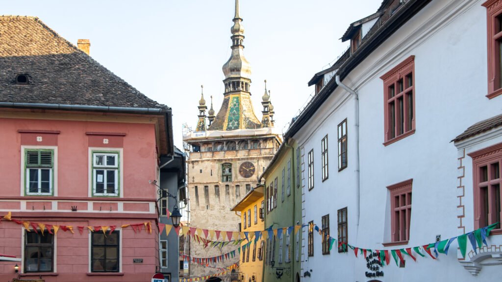 Colourful European street with pink, yellow, and white buildings.