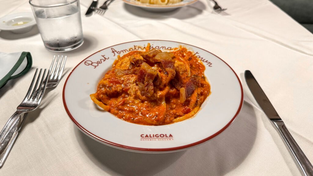Caligola Rome | Krista the Explorer Plate of amatriciana pasta at table in restaurant.