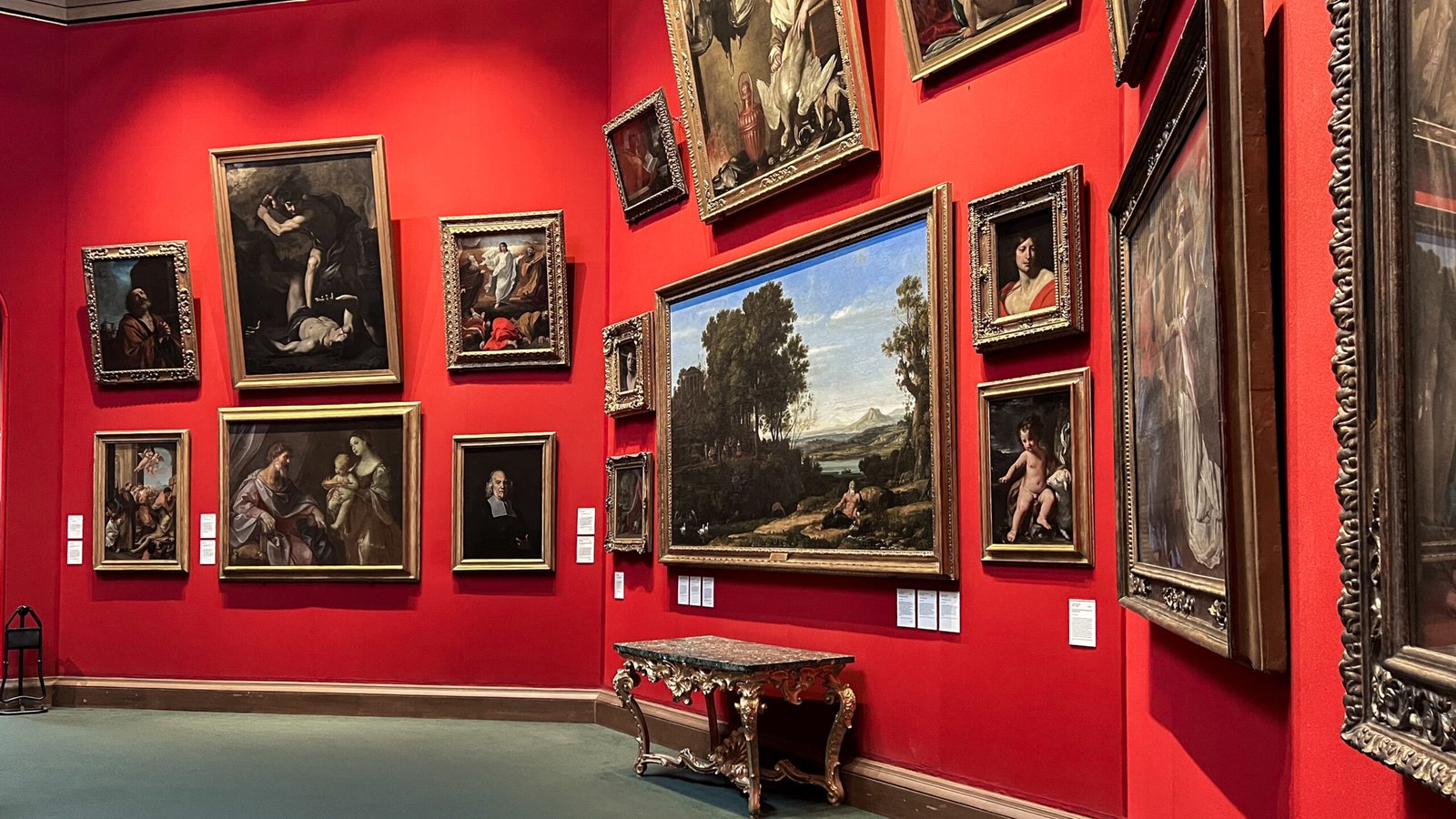 Edinburgh Museums | Krista the Explorer | Krista the Explorer Museum gallery with red walls and numerous framed classical paintings.