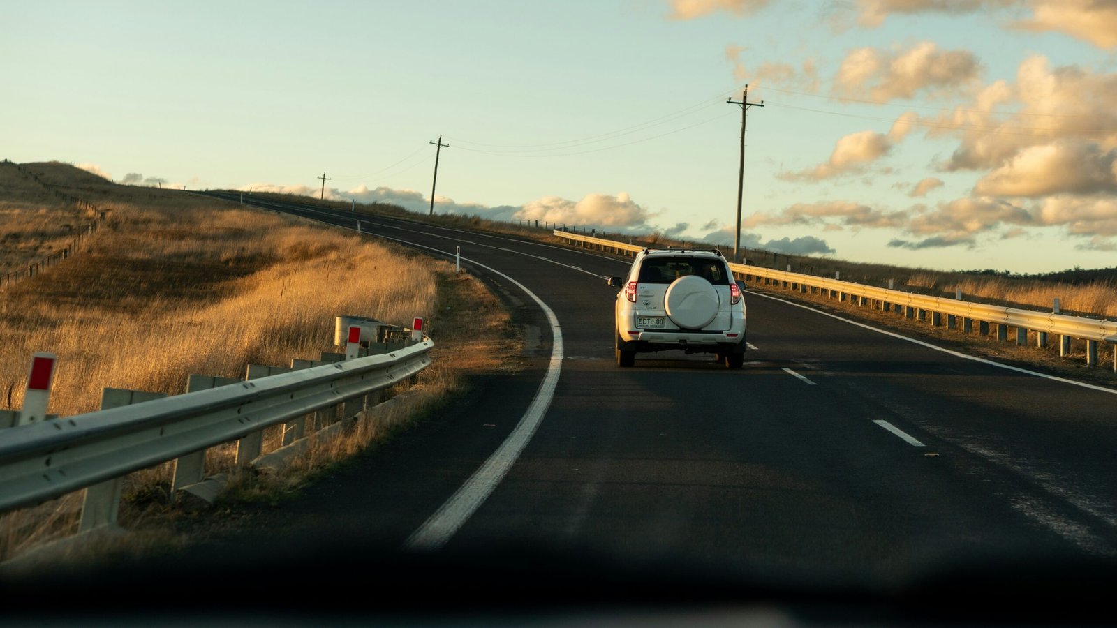 Car driving on road at sunset.