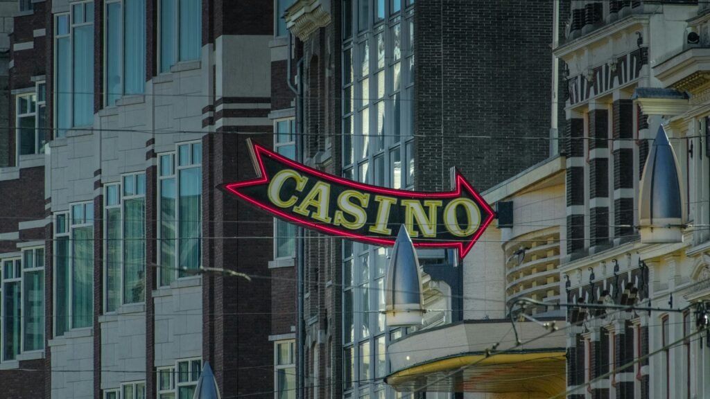Neon casino sign shaped like an arrow pointing right over a city street.